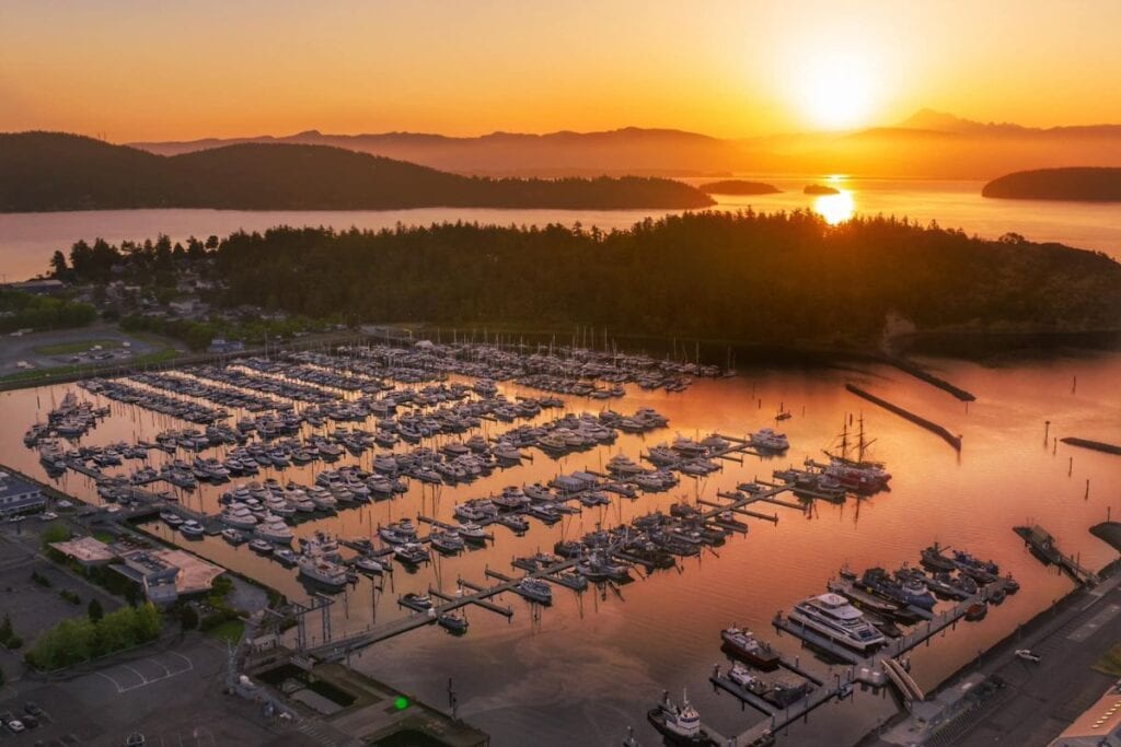 Aerial view of the Anacortes marina at sunset with boats and islands, highlighting scenic things to do in Anacortes.
